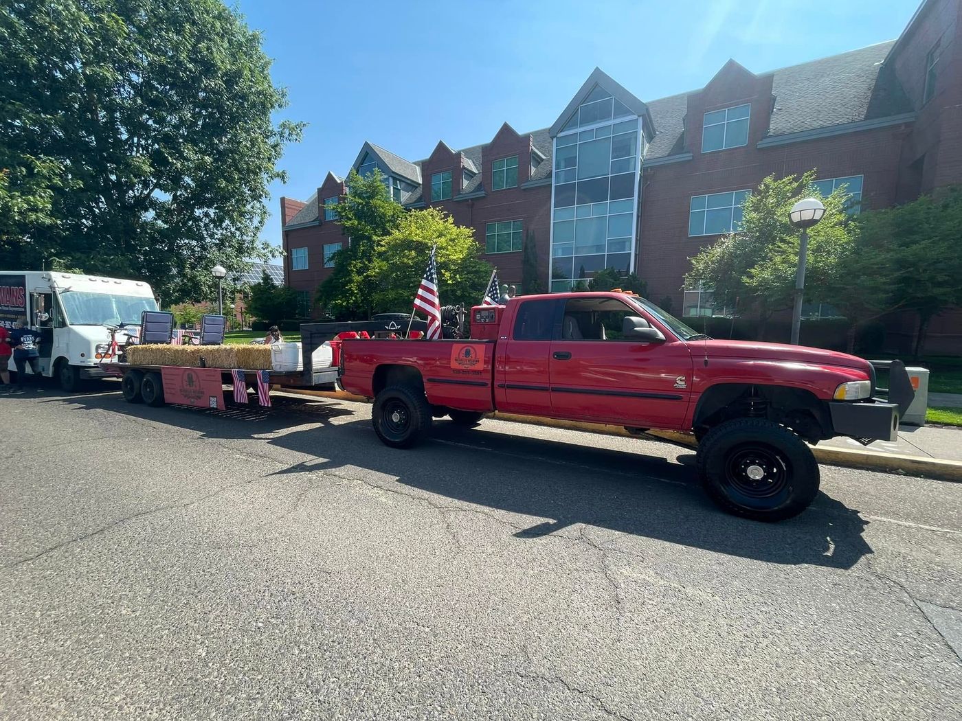 Red Dodge pickup on a custom flatbed with hitch