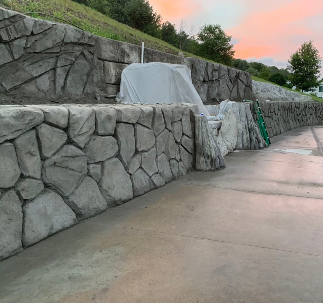 Stone-look retaining walls beside a poured concrete drive