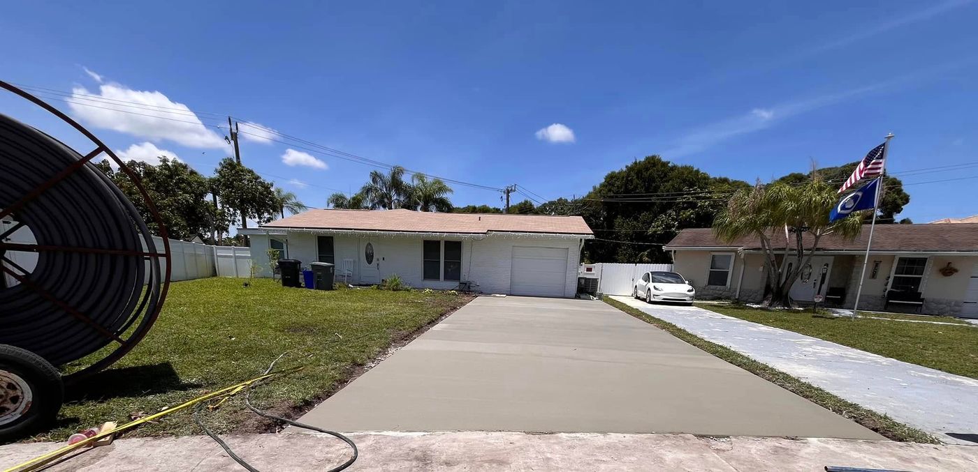 Long concrete driveway leading toward a Florida home