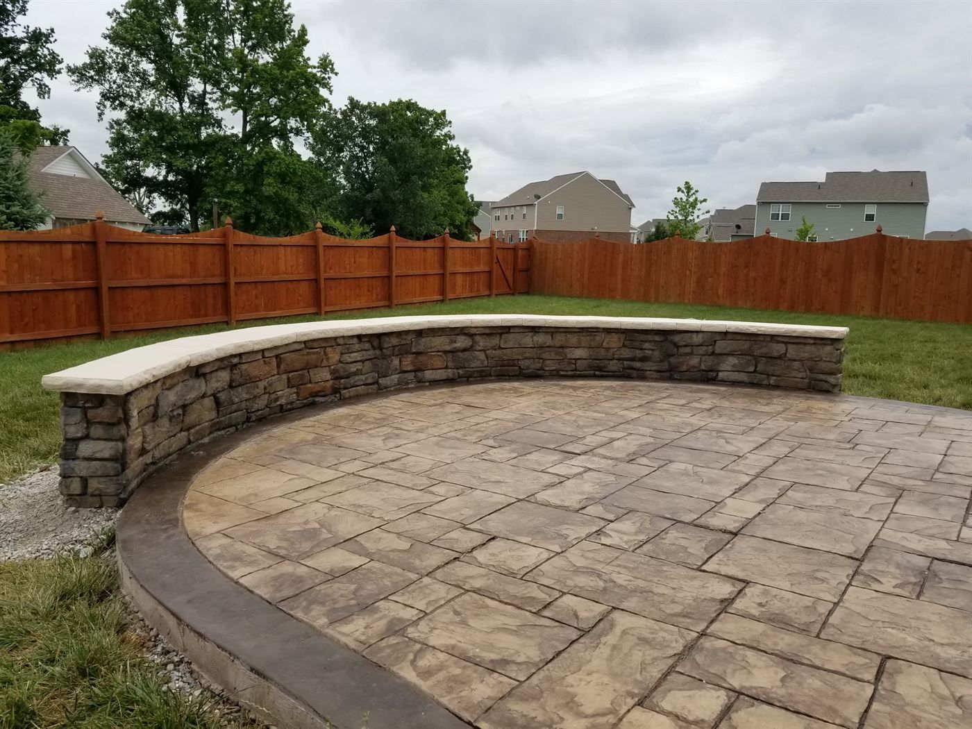 Stamped concrete patio with a curved seat wall