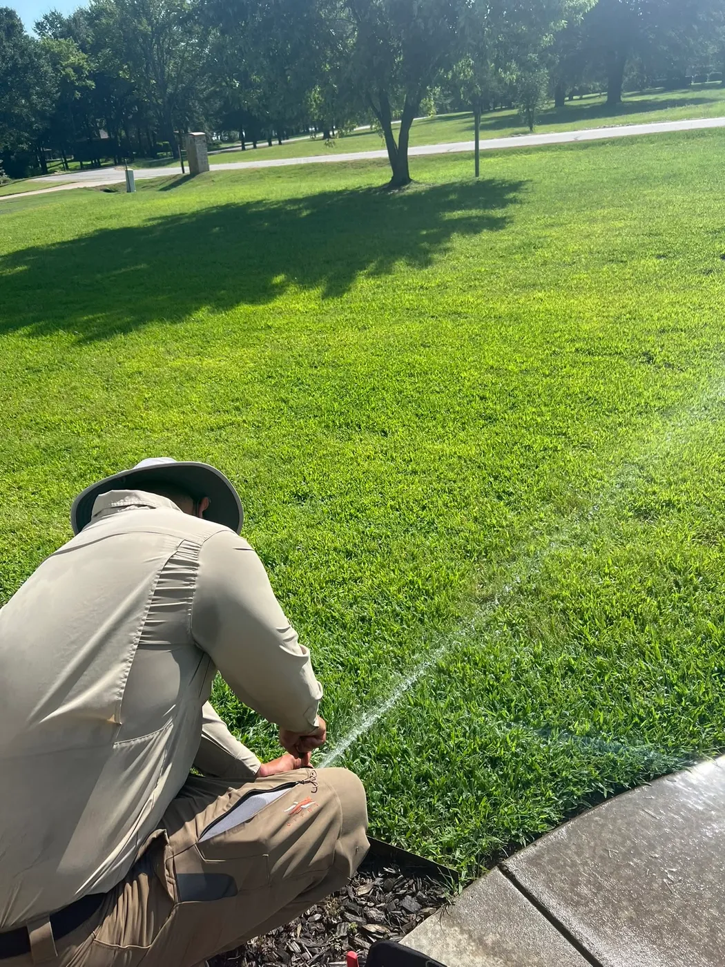Hood Landscape Solutions licensed irrigator adjusting a sprinkler head on a new lawn