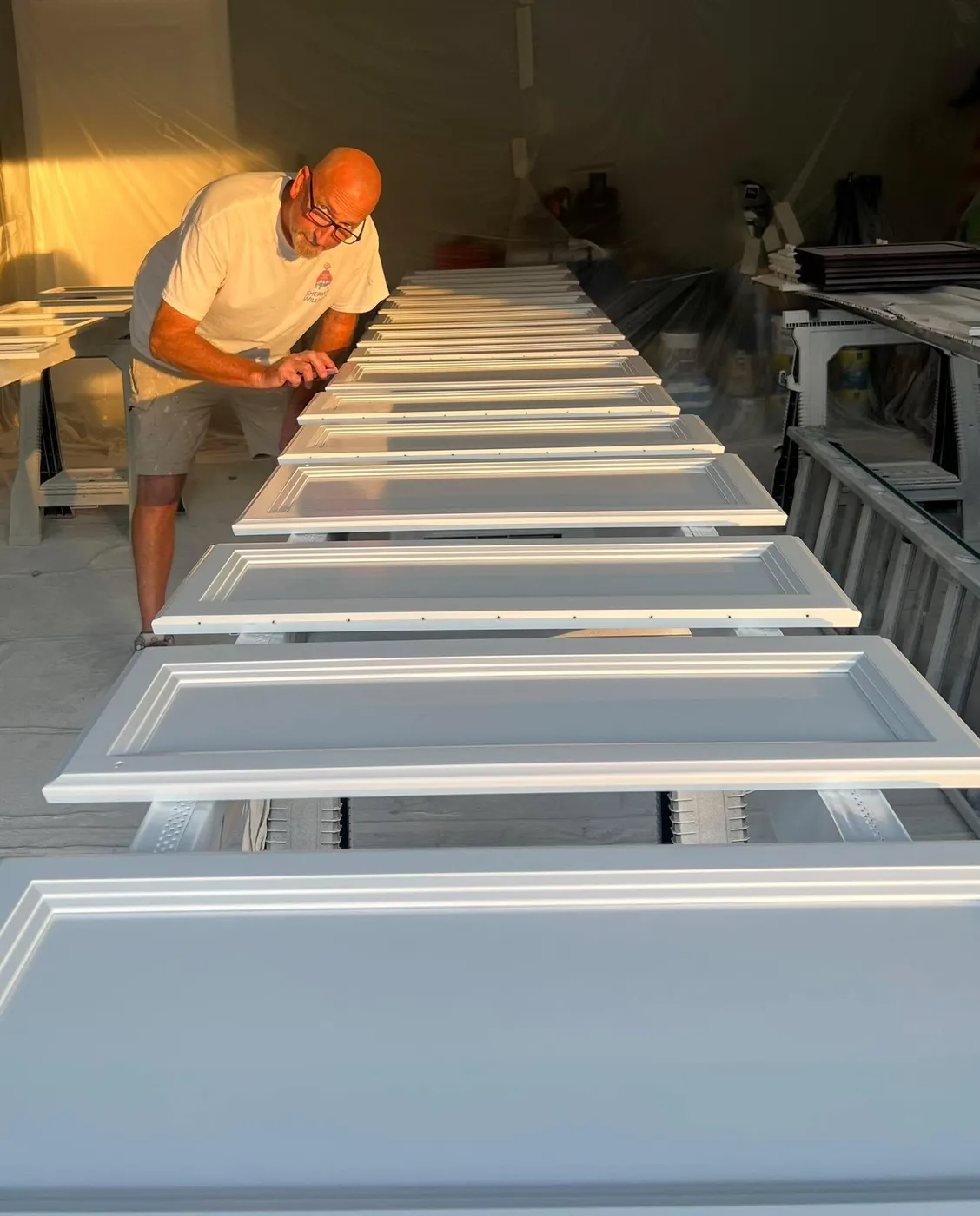 Ryan Garrity spray finishing a run of cabinet doors for a Pinellas County kitchen