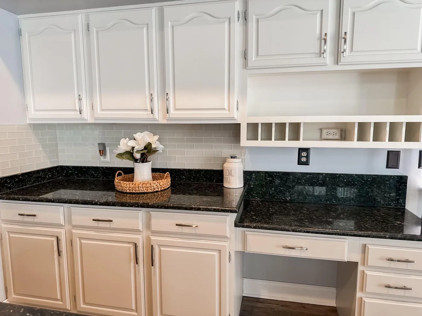 White kitchen cabinets refinished by Garrity Painting against black granite counters