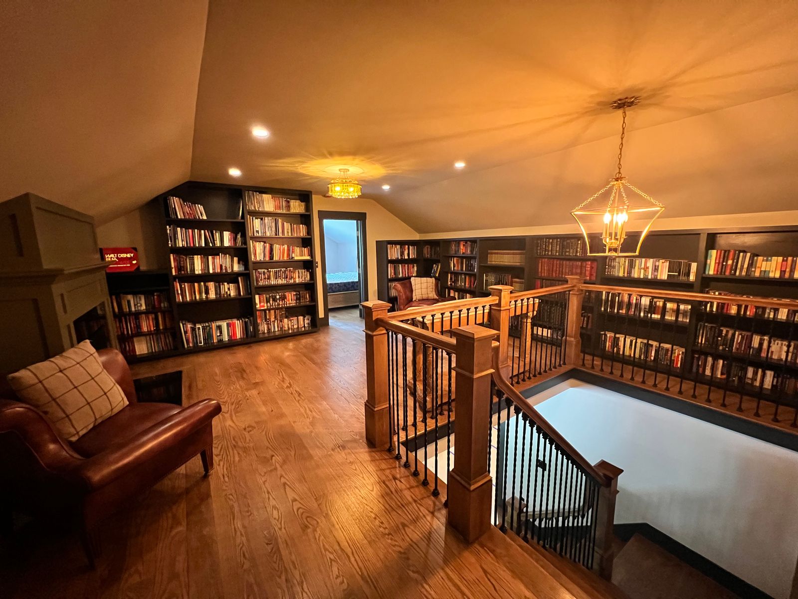 Library room with dark painted bookcases, walls and railing by Littlefield Painting