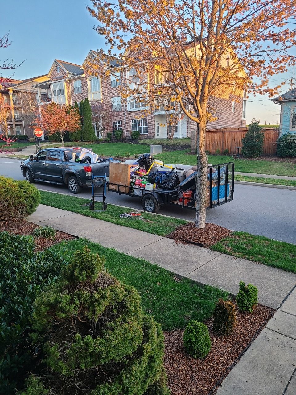 Matt's Haul it All truck and loaded trailer on a suburban street in fall