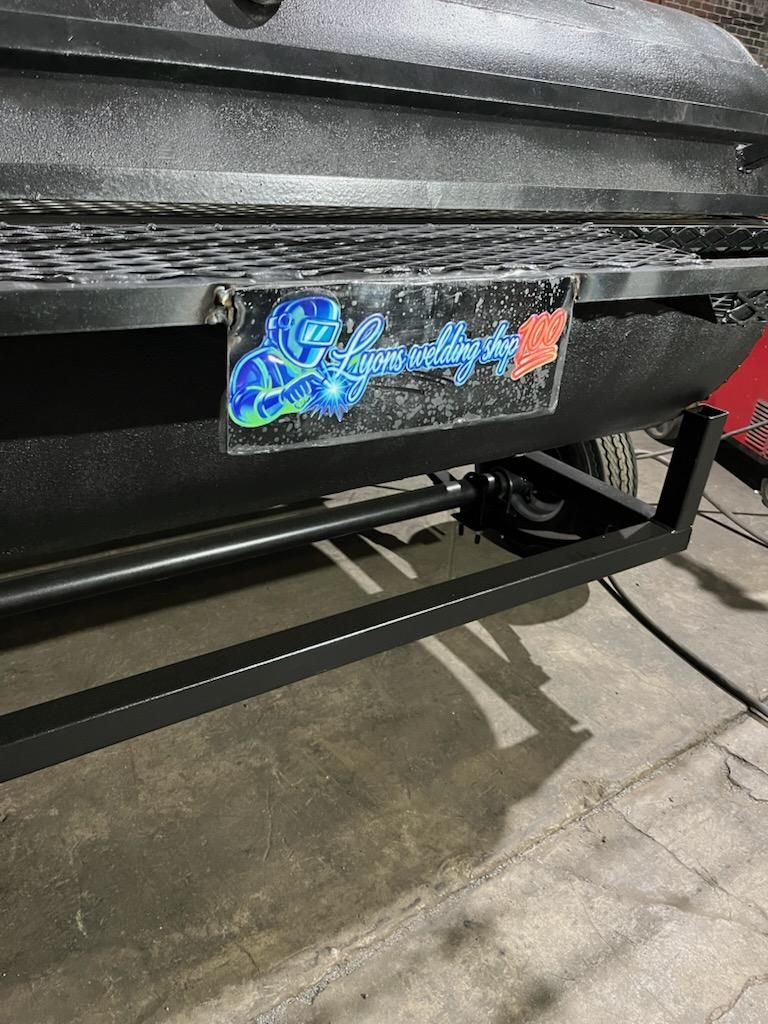 Lyons Welding Shop badge on a custom-built pig cooker