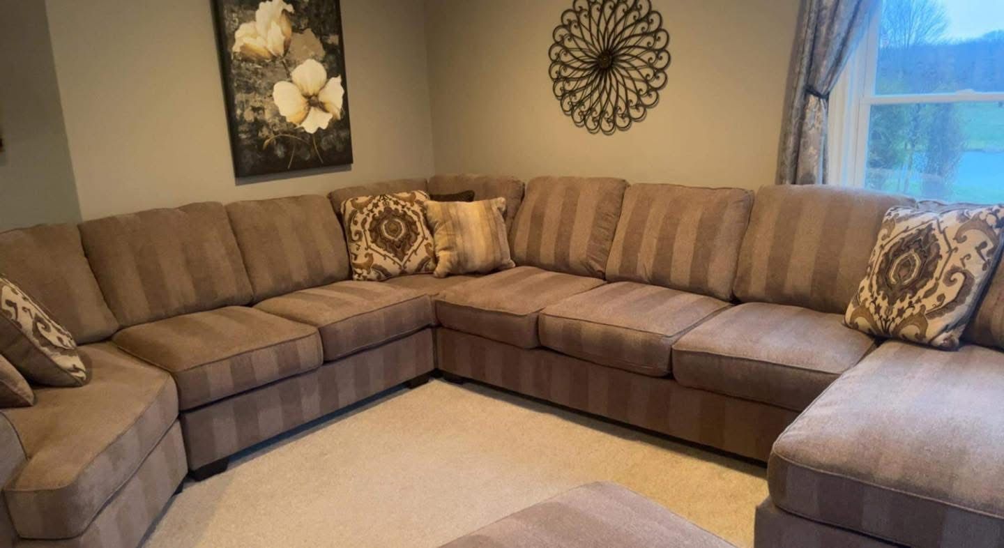 Sectional sofa and carpet with fresh vacuum lines in a home cleaned by Busy B's