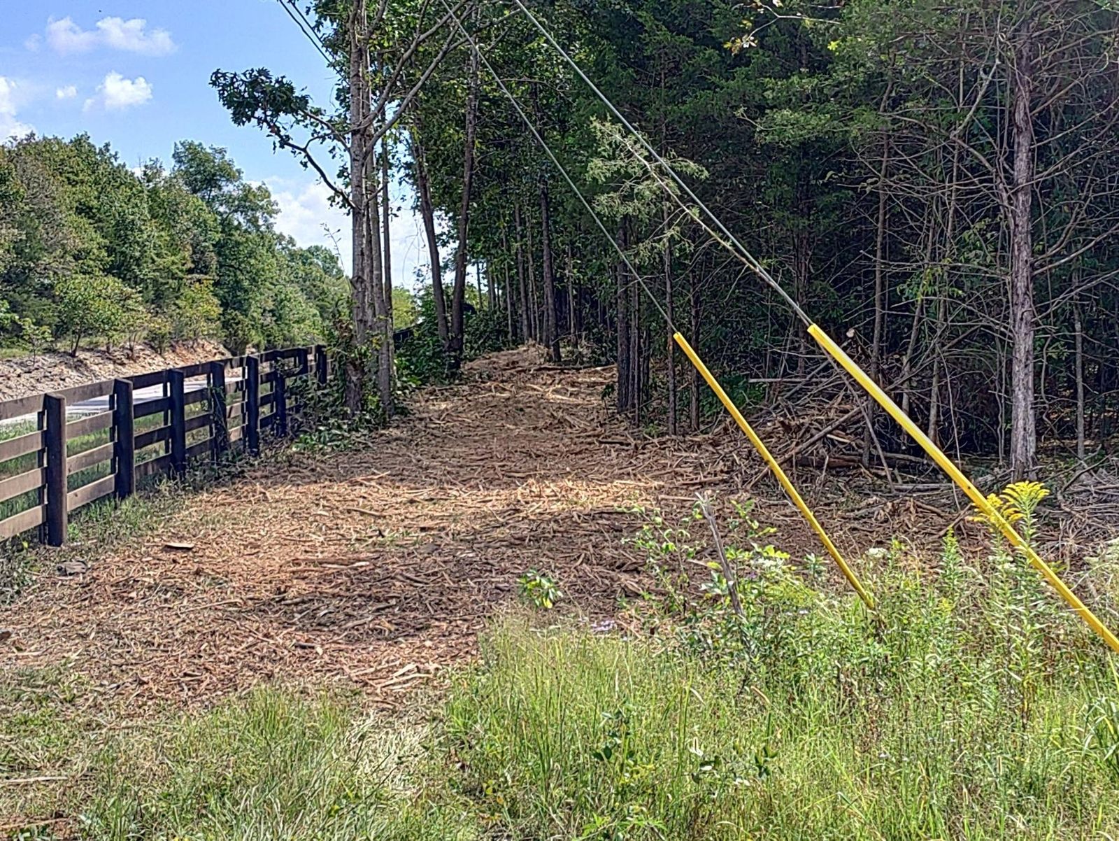 Mulched corridor along a black wood fence under a power line near Cornersville, TN
