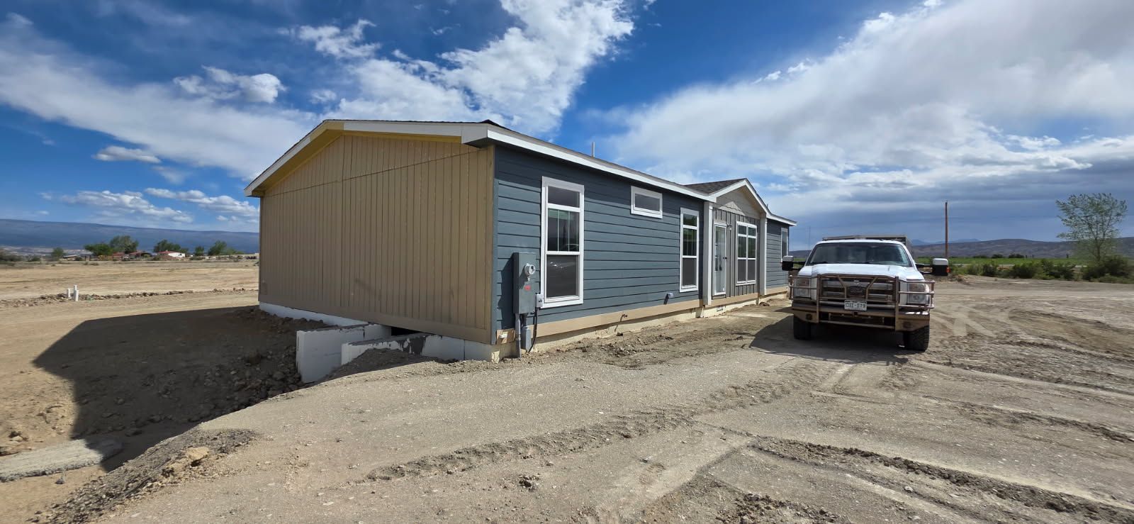 New modular home set on open land with the mesa behind it near Fruita