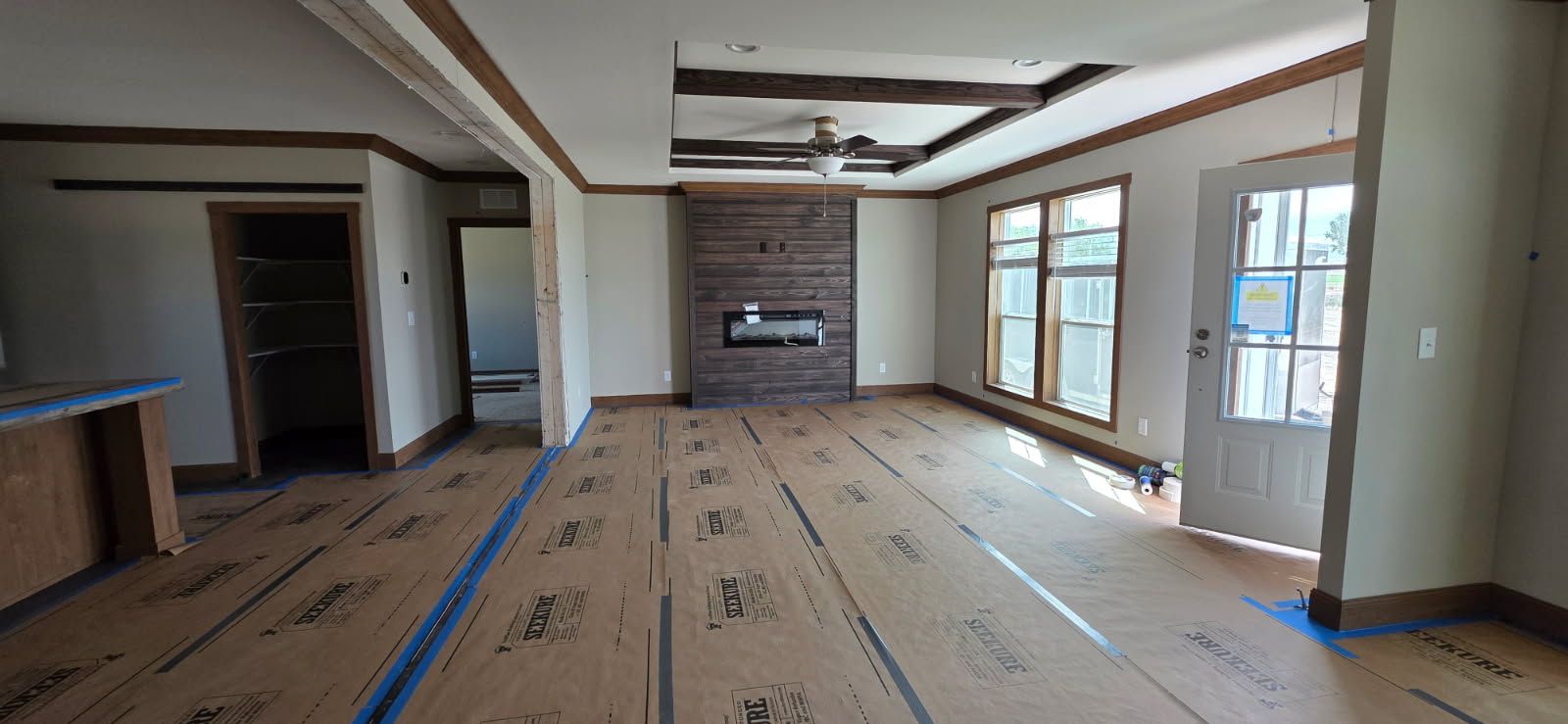 Finished great room with a stone fireplace wall