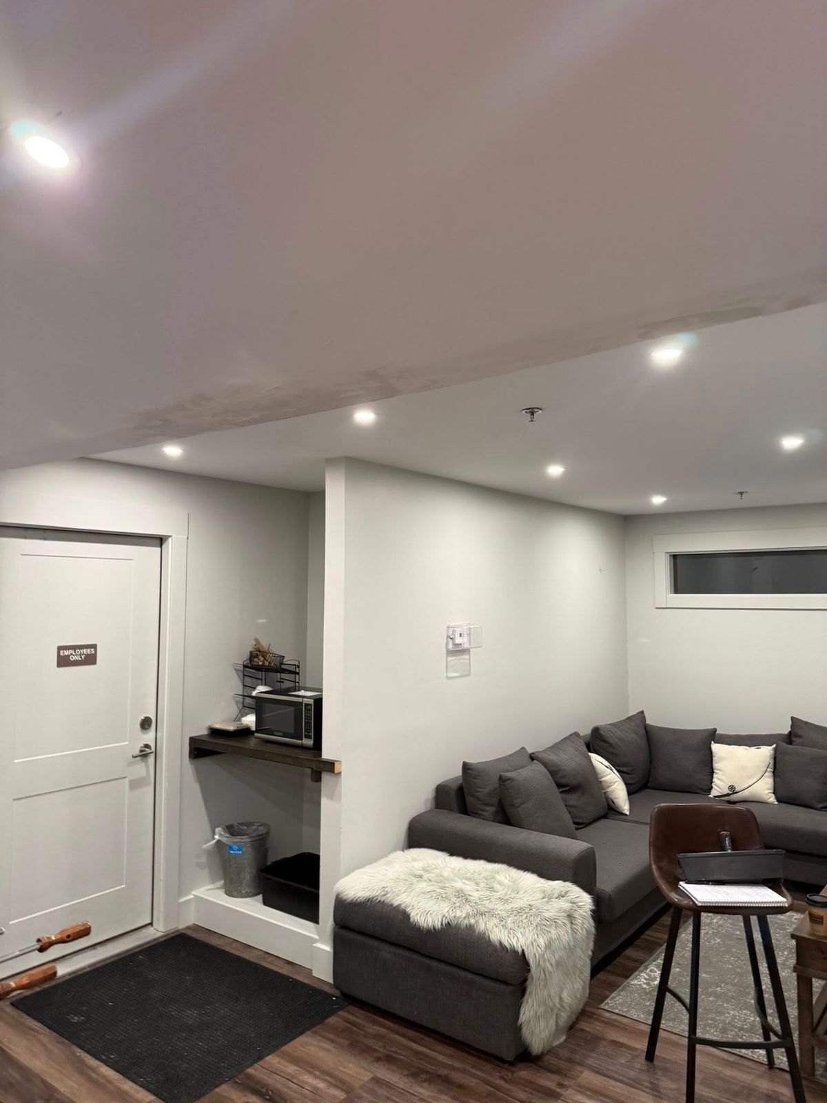 Finished room with a gray sofa, white walls and recessed lights
