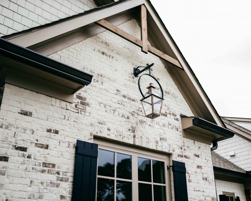 Brick gable with a copper lantern, finished in limewash with aged white texture