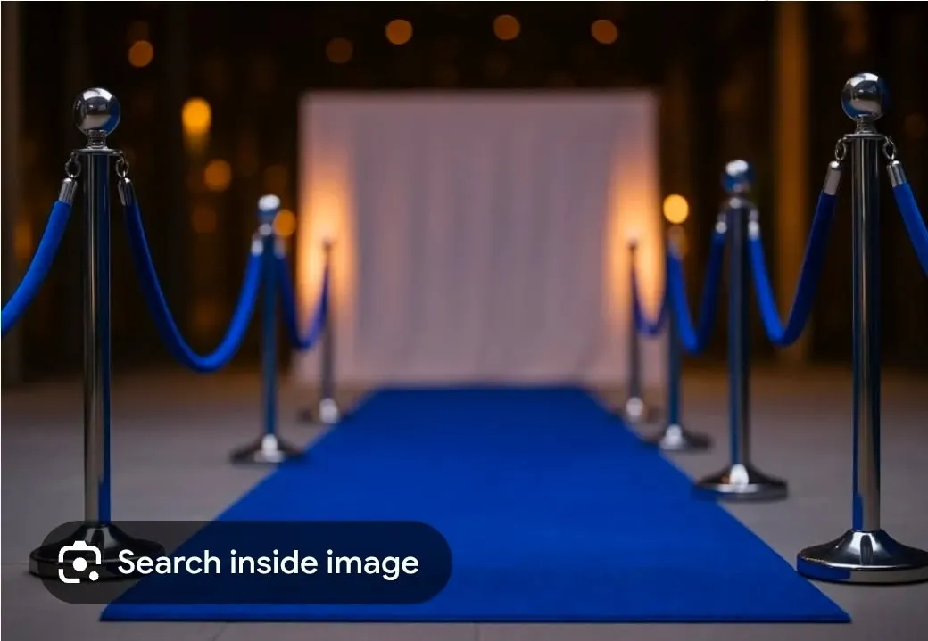 White drape backdrop with blue carpet and stanchions
