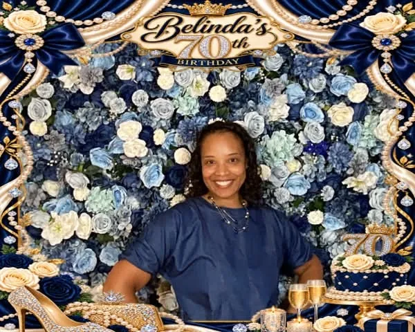 Guest in front of a blue and white flower wall backdrop