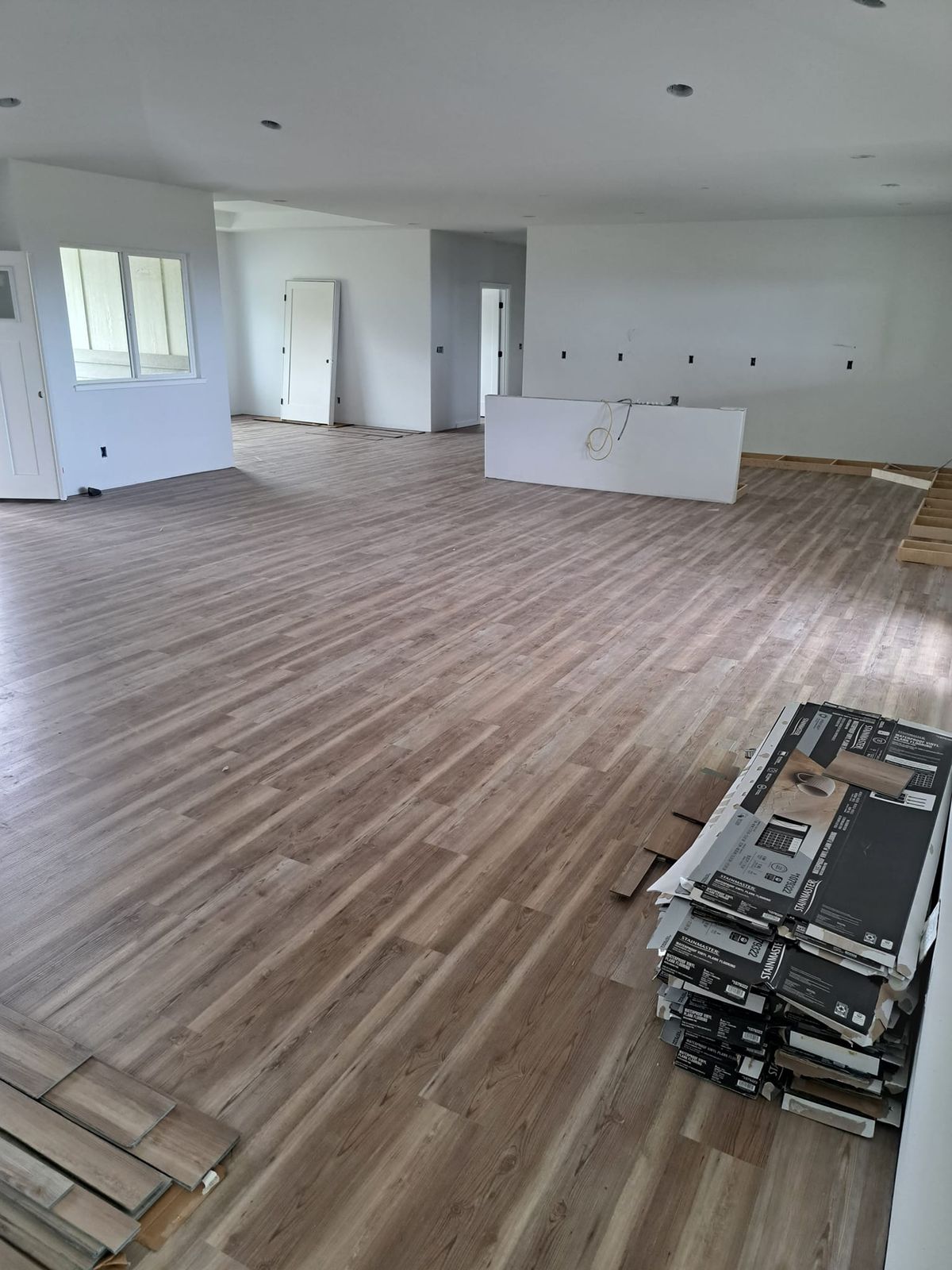 Wide plank flooring installed across an open living space