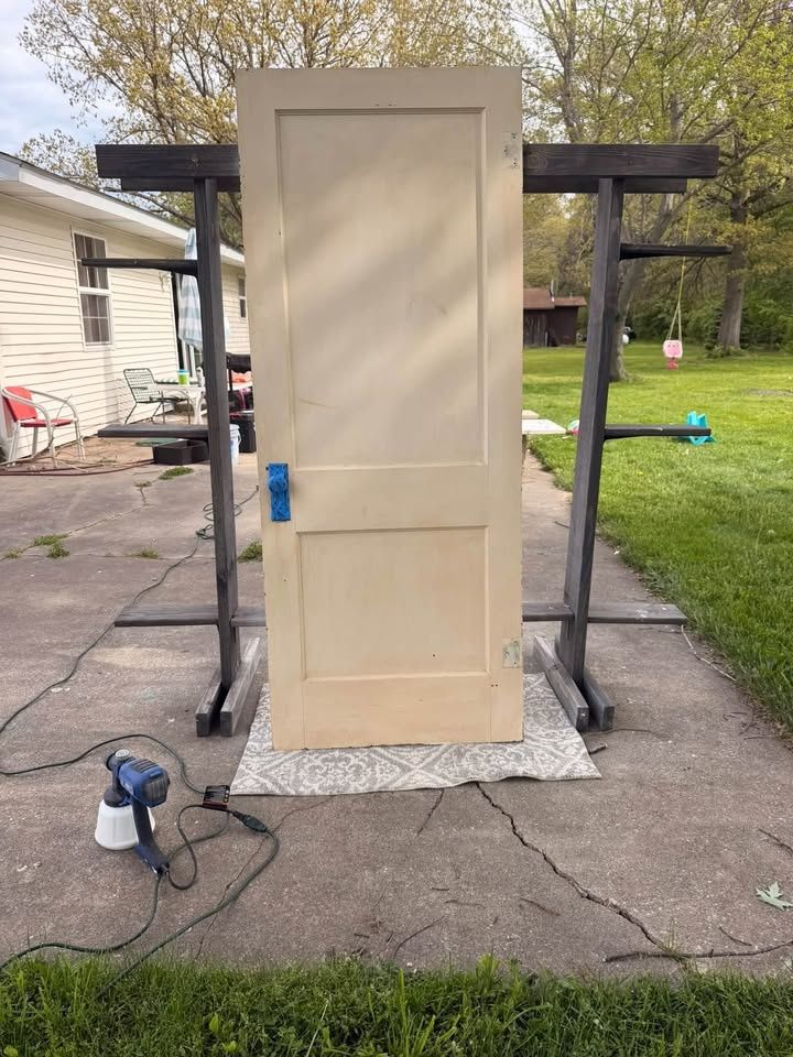 Refinished panel door standing on sawhorses outside the KJ Painting and Finishing shop in La Porte County, Indiana