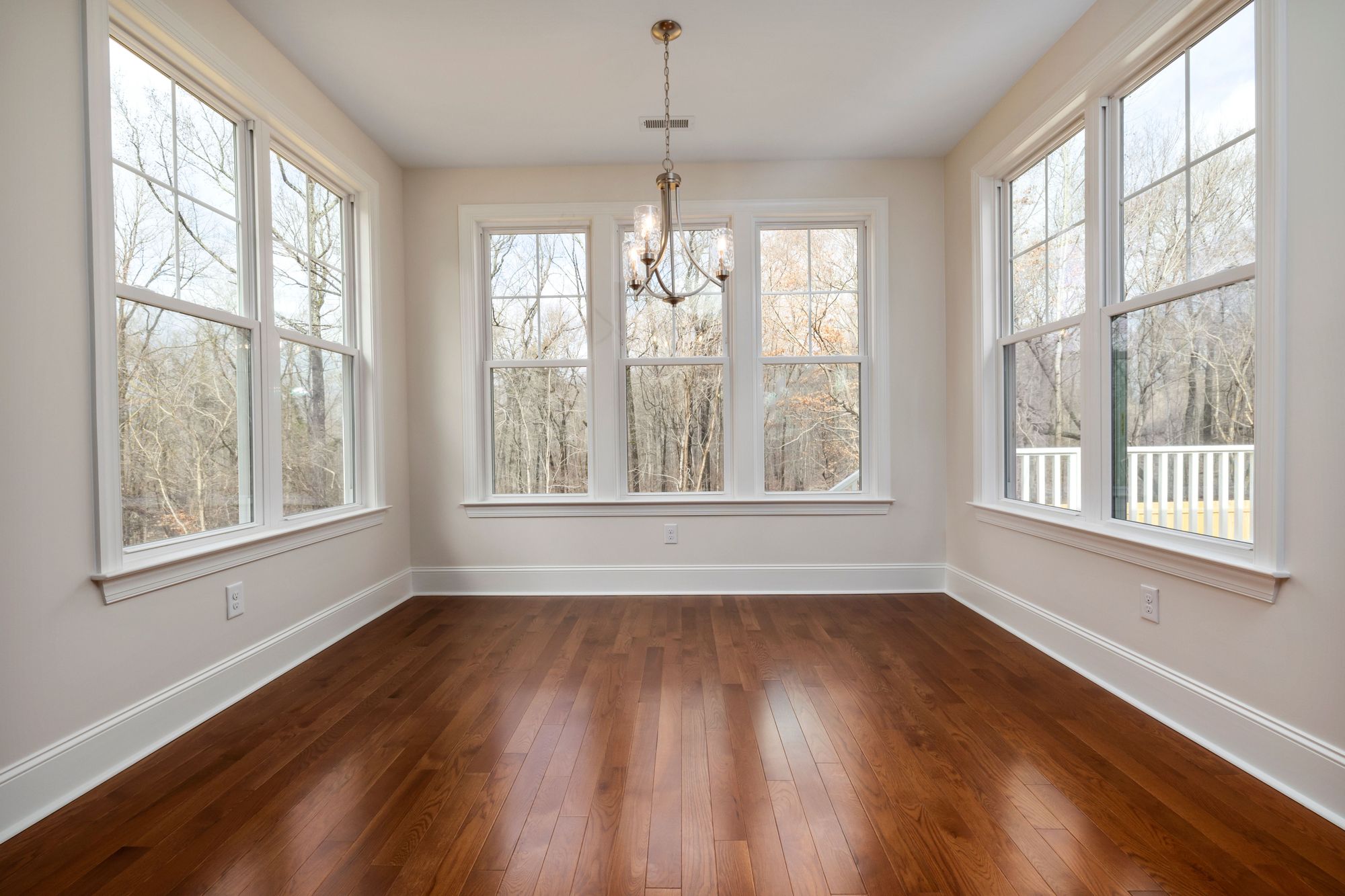 Sunroom with new hardwood flooring and white trim