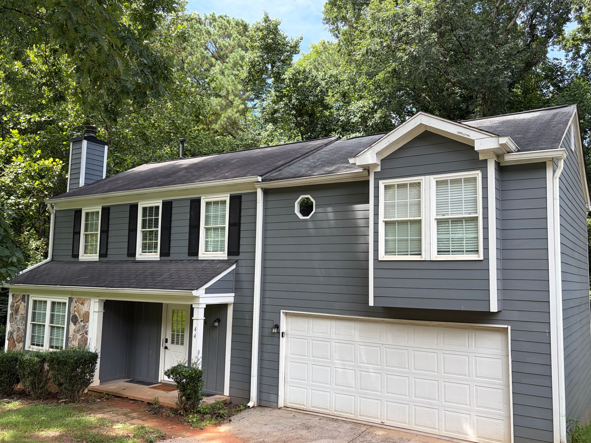 Gray two-story home with a new charcoal shingle roof