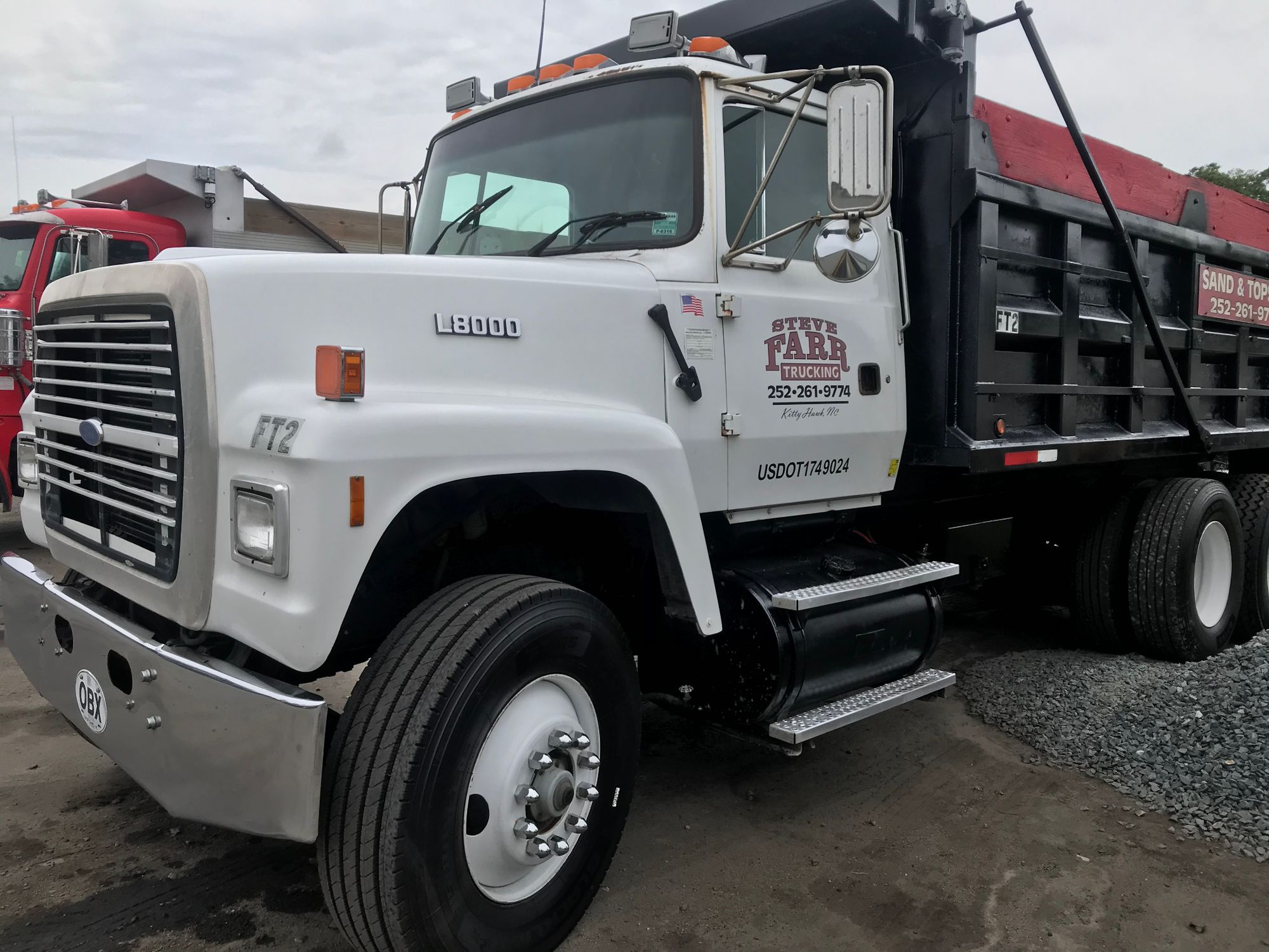 Farr Trucking Ford L8000 dump truck FT2 parked beside a gravel pile