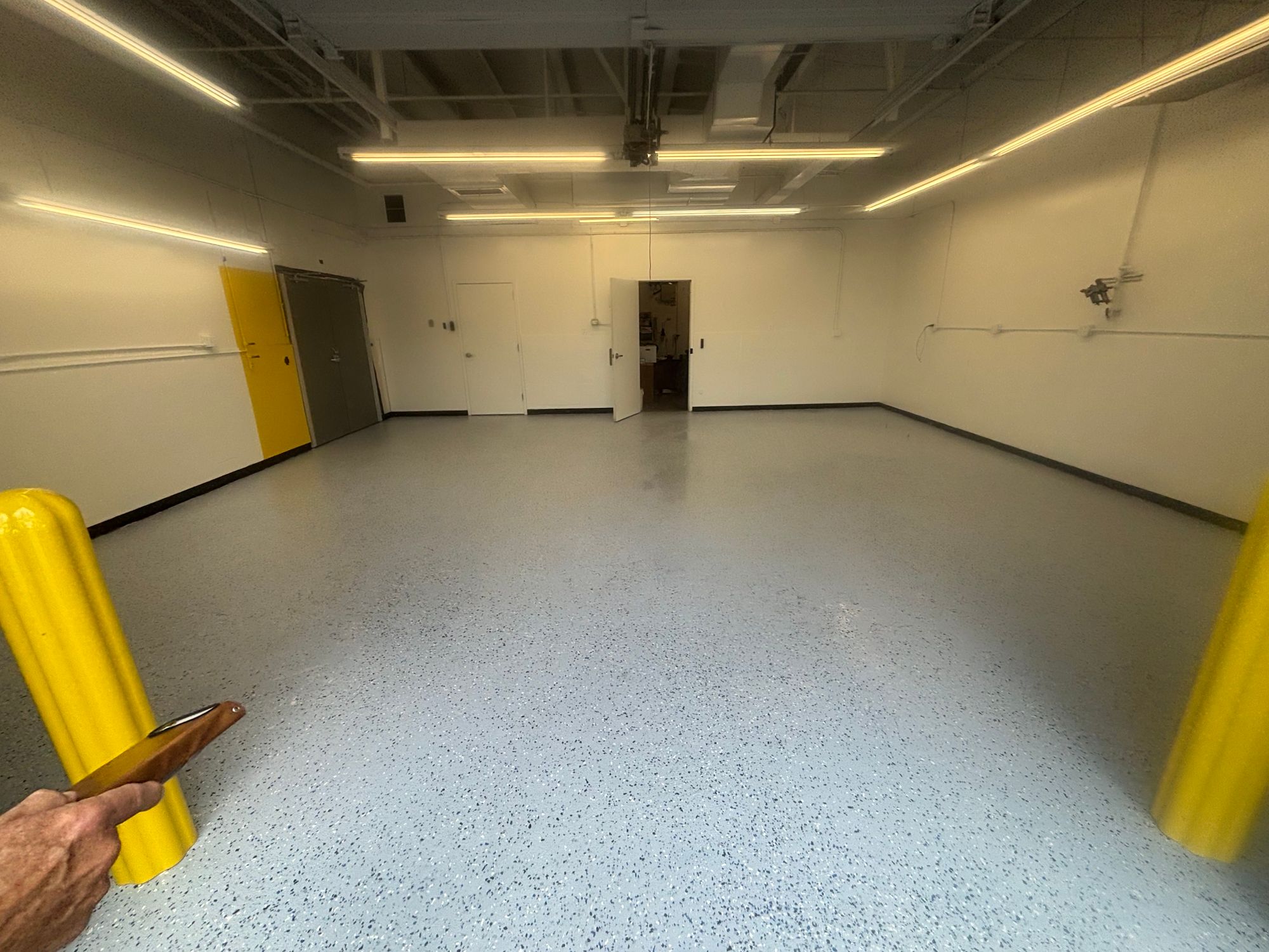 Commercial service bay with a new flake epoxy floor and yellow safety bollards