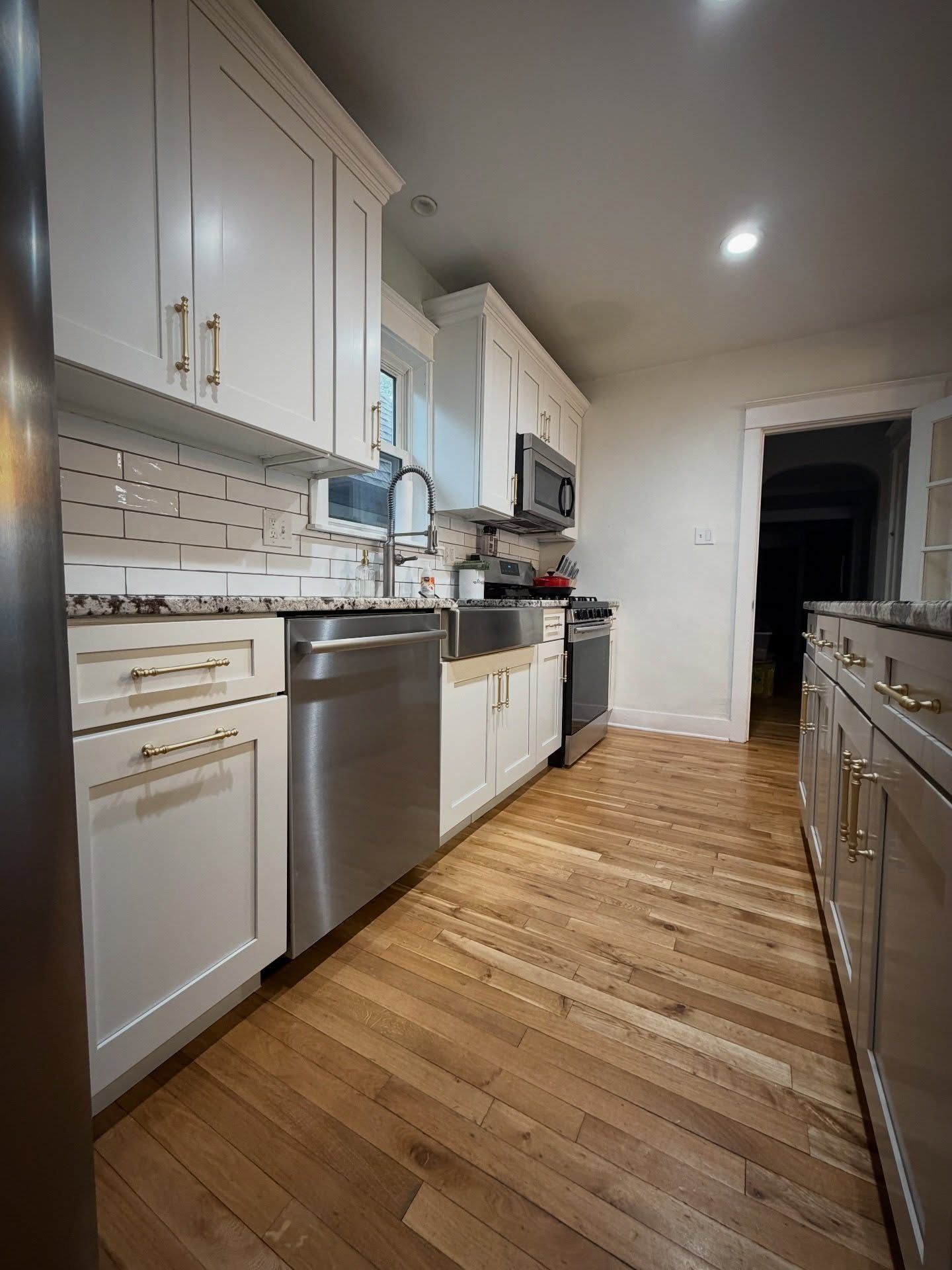 Galley kitchen with refinished white cabinets and a contrasting island