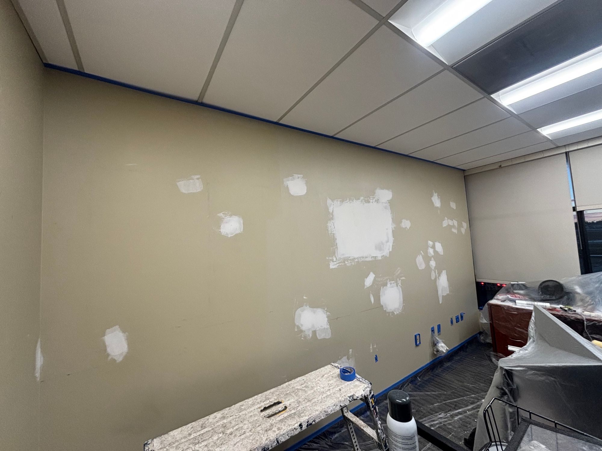 Office wall with drywall patches mudded and sanded before paint