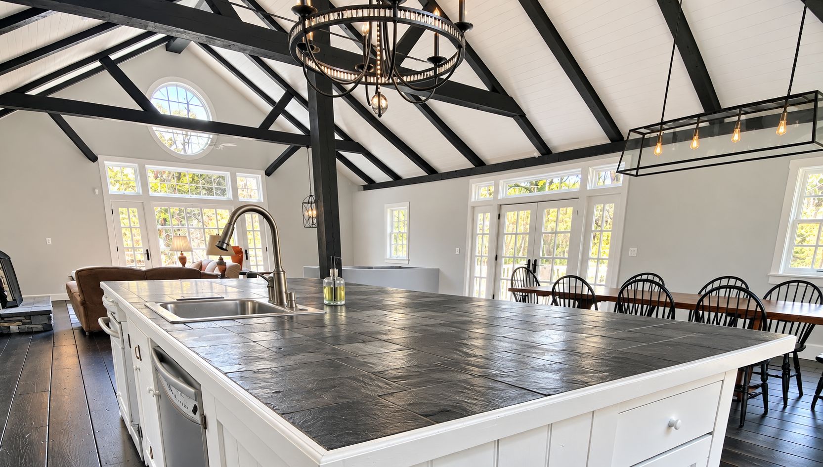 Converted barn great room MK Painting painted, with black beams, white ceilings and a slate island