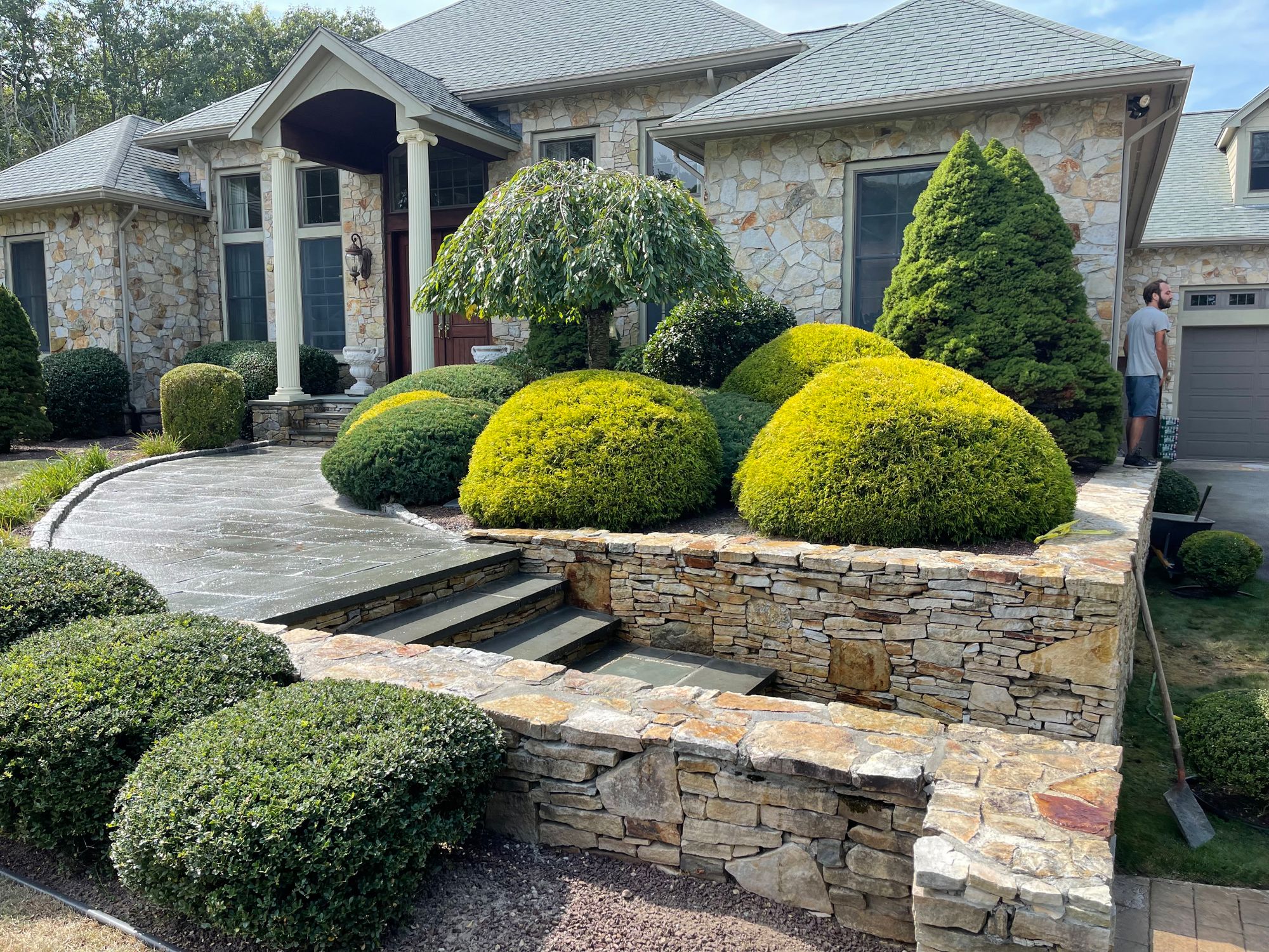 Stone veneer retaining wall, bluestone steps and landscaped front walkway at a Rhode Island home