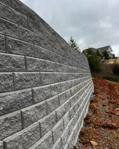 Enhance your outdoor space with our expert retaining wall construction service, providing durable and aesthetically pleasing solutions that prevent erosion while adding value and functionality to your home's landscape. for Precision Scapes in Jonesborough, TN