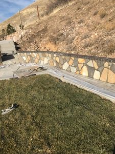 Our Boulder Rock Walls service offers custom-designed and expertly crafted rock walls that add natural beauty and functionality to your landscaping, while also enhancing the value of your property. for Hifo Construction in Spanish Fork, UT