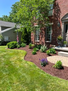 Our Mulching service helps homeowners improve the health and appearance of their outdoor spaces by applying a layer of protective materials to retain moisture, suppress weeds, and nourish plants. for Kunkle & Sons Property Maintenance in Akron, OH