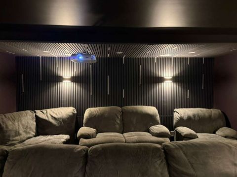 Finished home theater with recliners and wall sconces