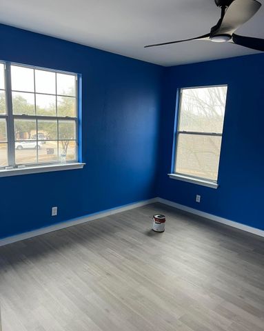Bedroom repainted in navy with white baseboards