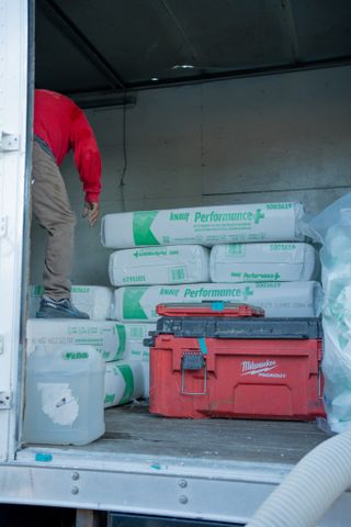 Foam Pro trailer loaded with insulation bales and a red tool case