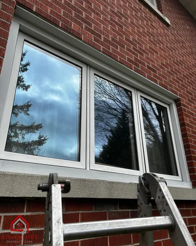 Signature Property Care cleaning windows on a Greater Sudbury property