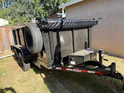 Black dump trailer parked on a residential lot