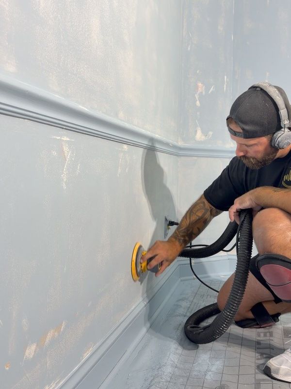 Mitch sanding a wall between coats of gloss