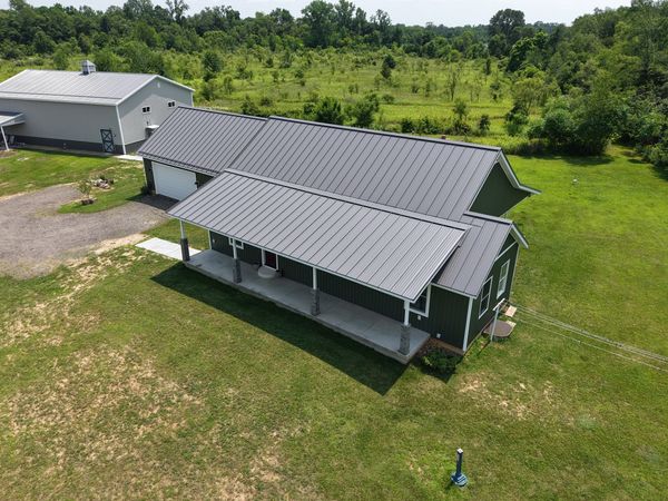 Grey metal roof on a pole building surrounded by open farmland