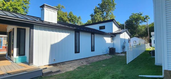 White metal board and batten siding on a home with black trim