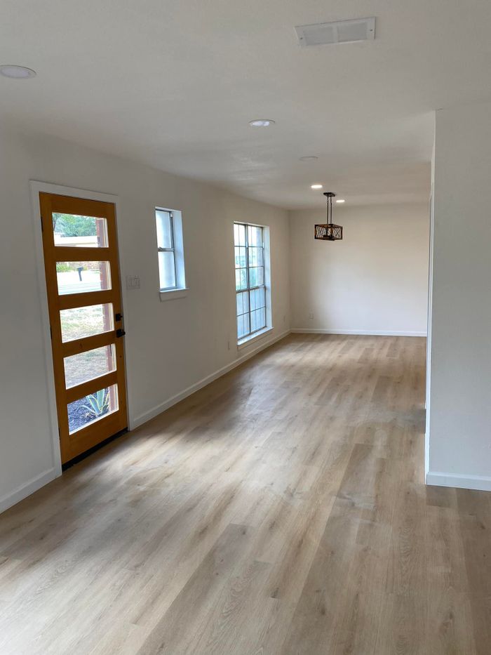 Flooring by BJR Construction in Fulshear and Katy, TX: finished room with wood-look plank flooring and a modern front door
