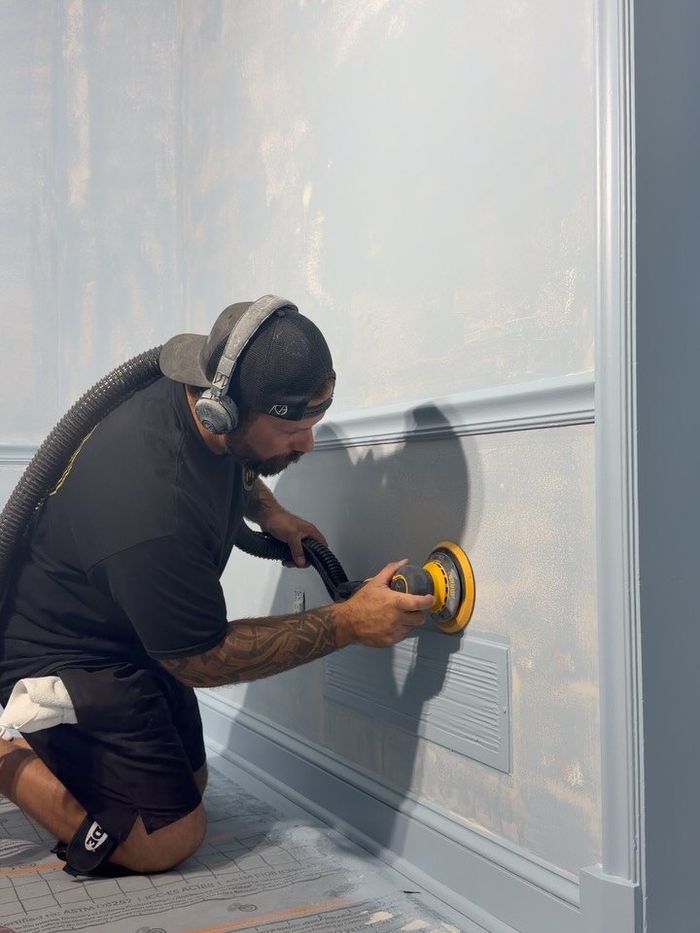 Mitch sanding a wall between coats