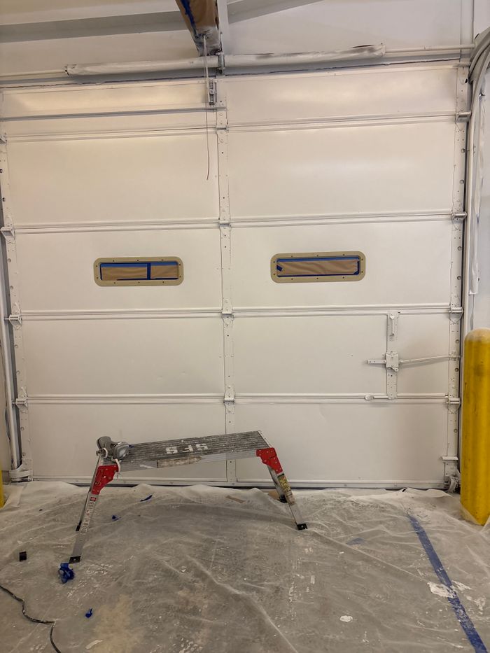 Garage bay masked off with plastic before coating
