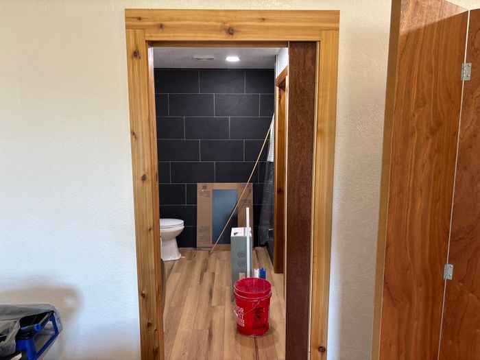 Finished bathroom with dark tile and cedar trim