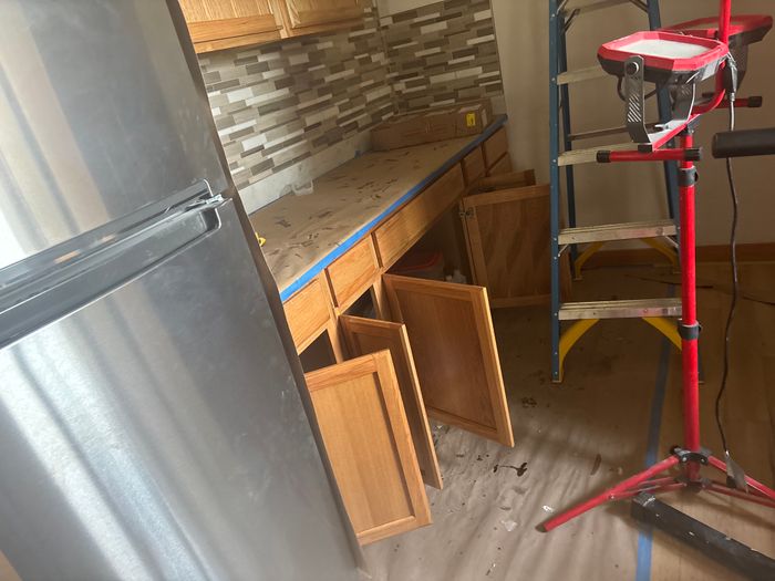 Kitchen mid-remodel with backsplash and cabinet doors off