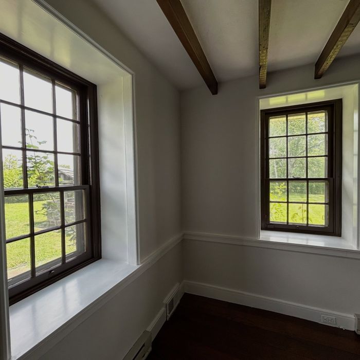 Deep farmhouse window with restored brown sash
