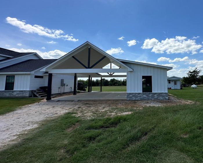 Custom home with covered entry and open Texas acreage behind it