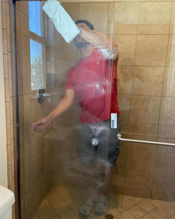 Installer fitting a glass shower door