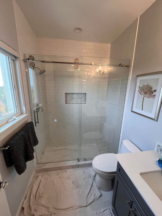 Sliding glass shower door with white subway tile