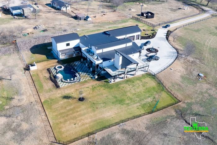 Aerial view of a modern home with a pool and fresh lawn