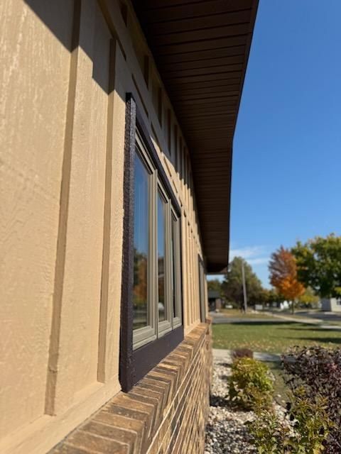 Painted siding with dark window trim along the side of the building